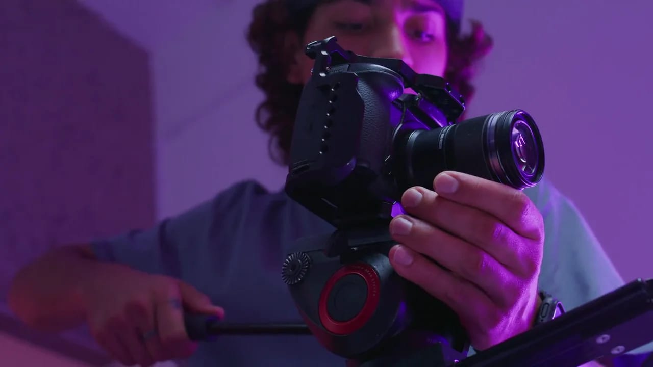 Neon ışıkta sinema kamerasıyla çekim yapan yönetmen — post prodüksiyon hizmeti